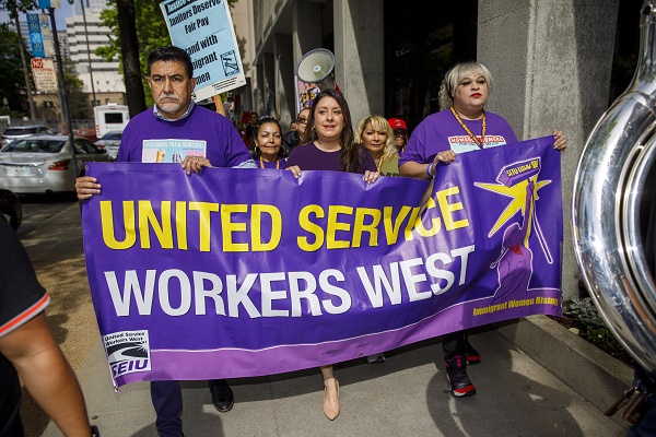 SEIU President David Huerta (left) and Assemblywoman Luz Rivas (center), and SEIU and SEIU-USWW workers marching in Downtown Sacramento toward the State Capitol.